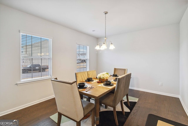 dining space featuring a wealth of natural light, dark hardwood / wood-style floors, and an inviting chandelier