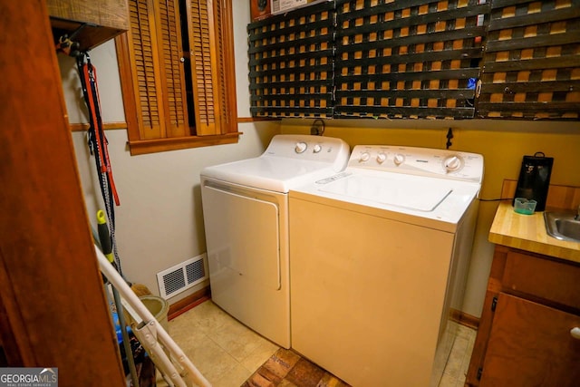 laundry room with sink, cabinets, independent washer and dryer, and light tile patterned floors