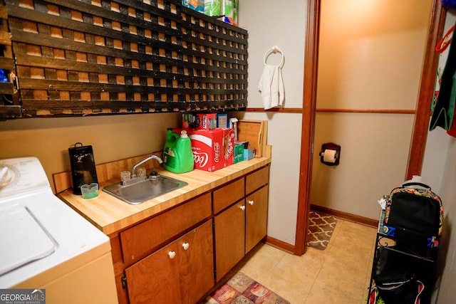 washroom featuring cabinets, light tile patterned floors, sink, and separate washer and dryer