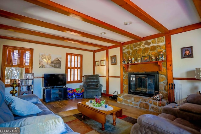 living room with plenty of natural light, wood-type flooring, beamed ceiling, and a fireplace