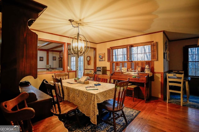 dining area with plenty of natural light, wood-type flooring, french doors, and ornamental molding