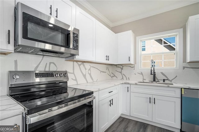 kitchen featuring sink, backsplash, appliances with stainless steel finishes, white cabinets, and ornamental molding