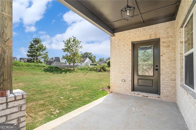 doorway to property with a lawn