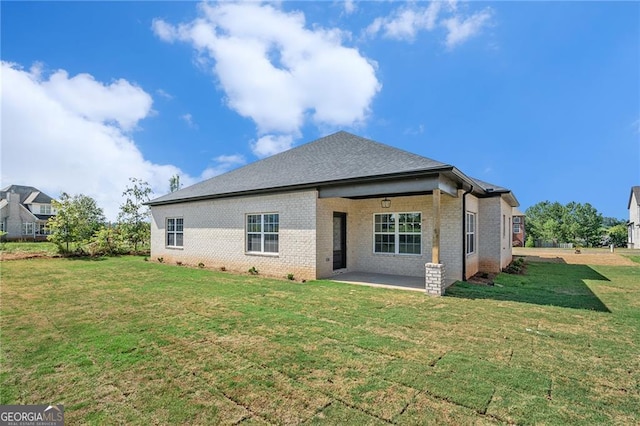 rear view of house featuring a lawn and a patio area