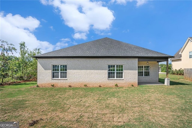 back of house with a lawn and a patio