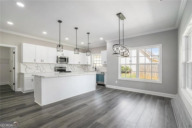 kitchen with a center island, white cabinets, hanging light fixtures, and appliances with stainless steel finishes