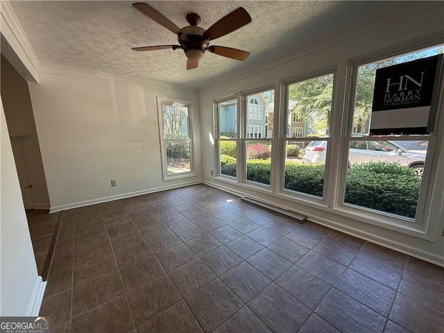 empty room featuring ceiling fan, ornamental molding, and a textured ceiling