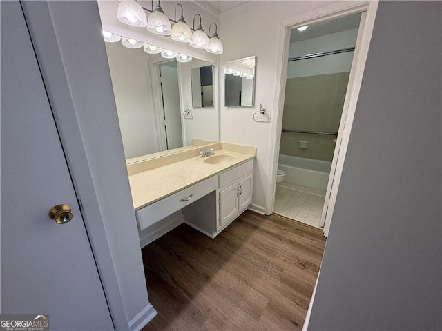 full bathroom featuring hardwood / wood-style floors, vanity, bathing tub / shower combination, and toilet