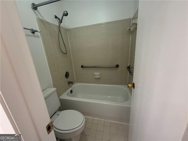 bathroom featuring tile patterned flooring, tiled shower / bath combo, and toilet