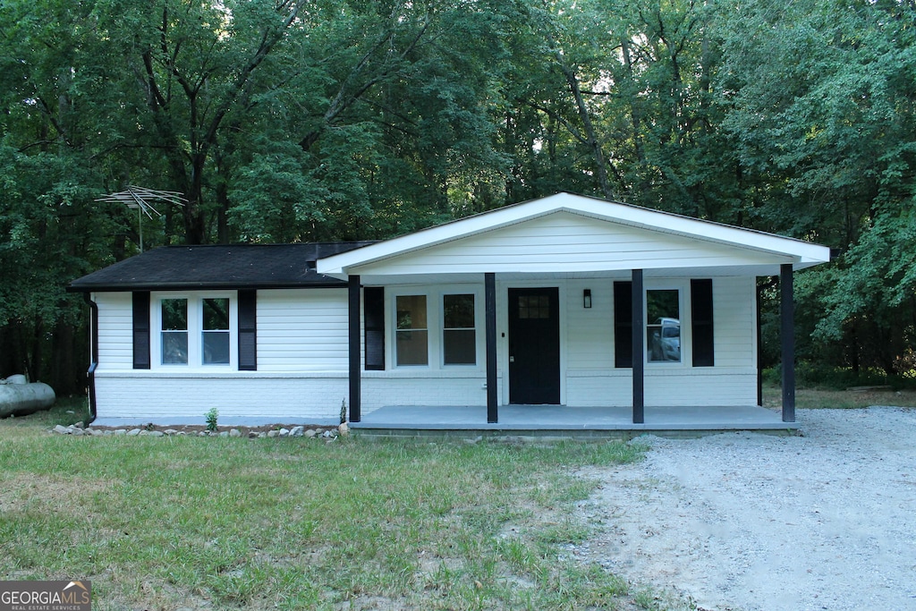 view of front of home featuring covered porch and a front lawn