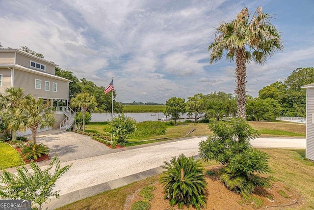 surrounding community with a lawn and a water view