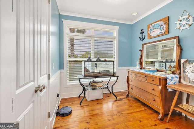 sitting room with crown molding and light hardwood / wood-style flooring