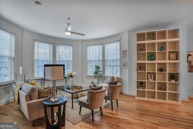 living area with ceiling fan and light wood-type flooring