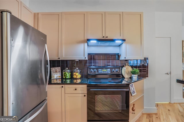 kitchen featuring tasteful backsplash, black electric range, stainless steel fridge, and light hardwood / wood-style floors