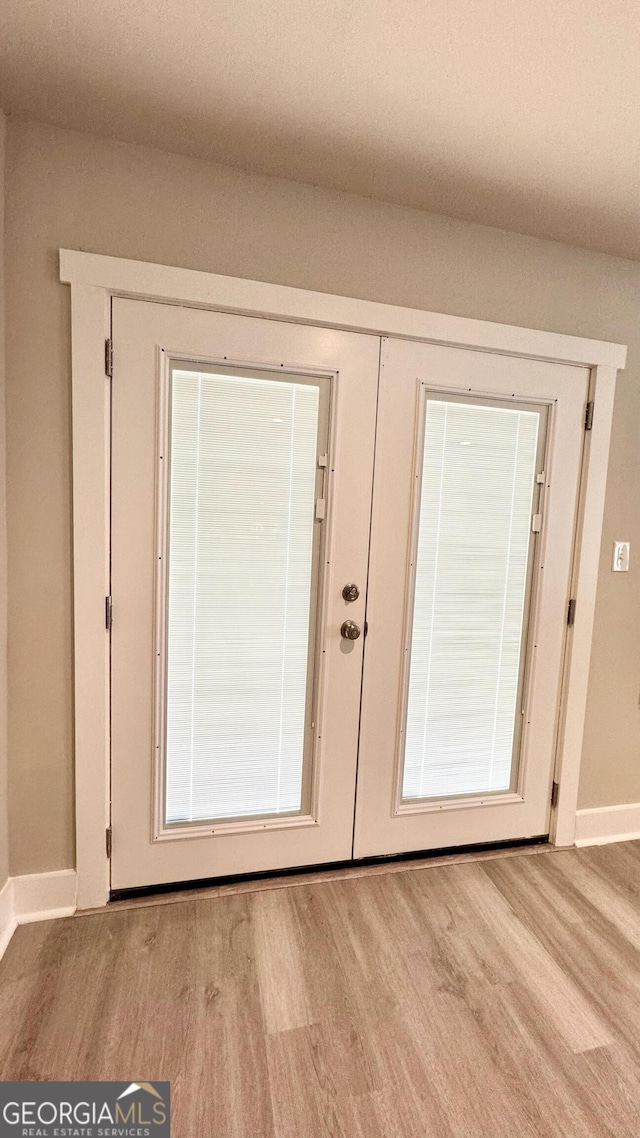 doorway to outside featuring french doors and light wood-type flooring