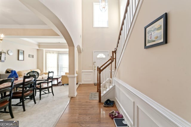 foyer entrance featuring hardwood / wood-style floors, an inviting chandelier, and crown molding