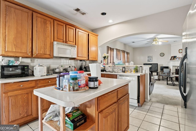 kitchen with ceiling fan, sink, light tile patterned floors, white appliances, and a kitchen island