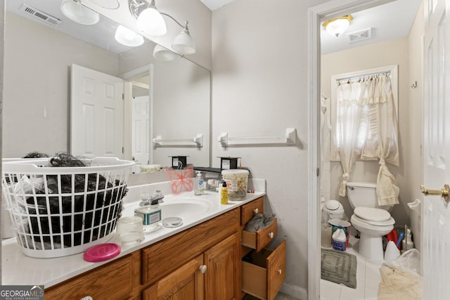 bathroom featuring tile patterned flooring, vanity, and toilet