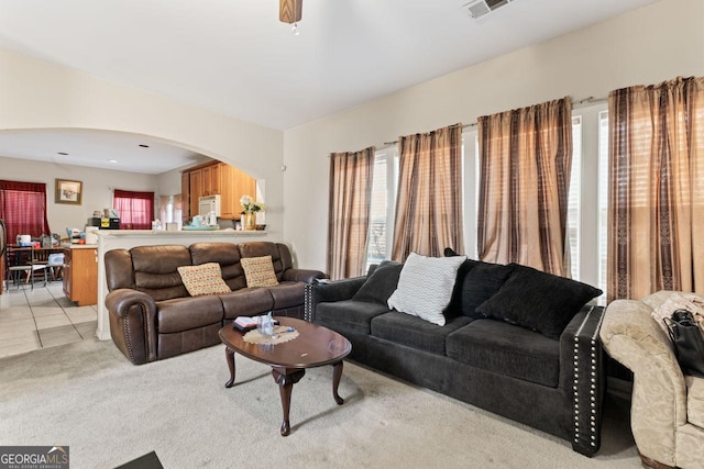 carpeted living room with ceiling fan