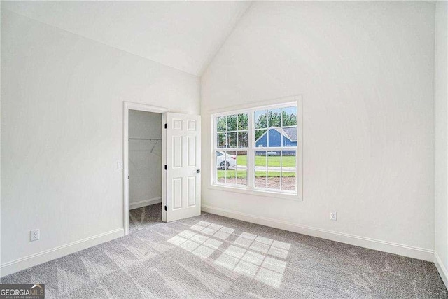 empty room with light colored carpet and vaulted ceiling