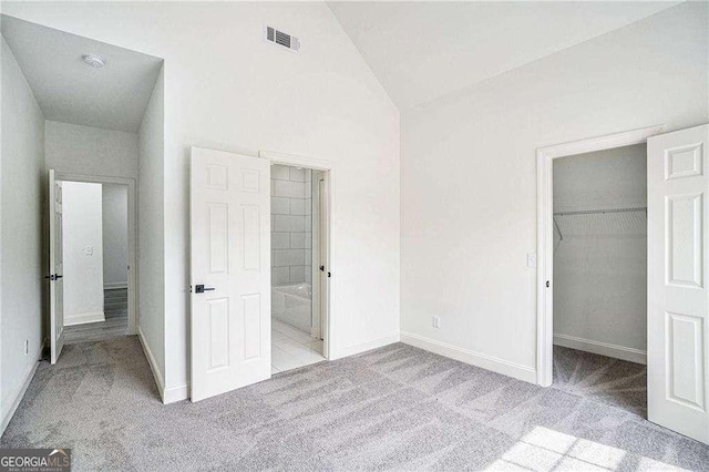 unfurnished bedroom with a closet, light colored carpet, and vaulted ceiling