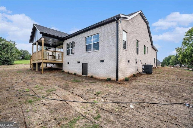 rear view of house with central AC unit and a deck