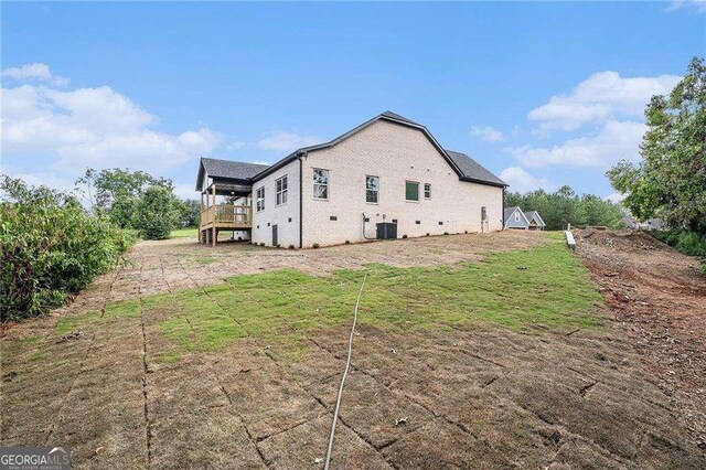 view of property exterior with central AC, a yard, and a deck