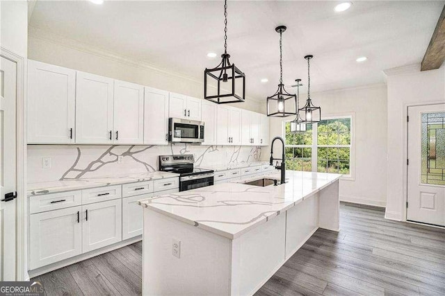 kitchen with white cabinets, a center island with sink, sink, and appliances with stainless steel finishes