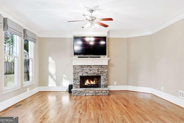 unfurnished living room featuring hardwood / wood-style flooring, ceiling fan, ornamental molding, and a fireplace