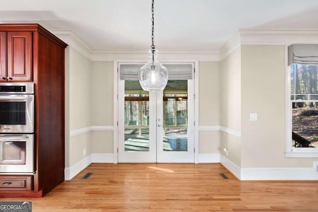 unfurnished dining area with crown molding, french doors, and light hardwood / wood-style floors