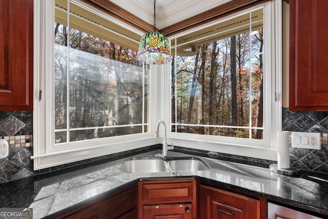 kitchen with backsplash, hanging light fixtures, and sink