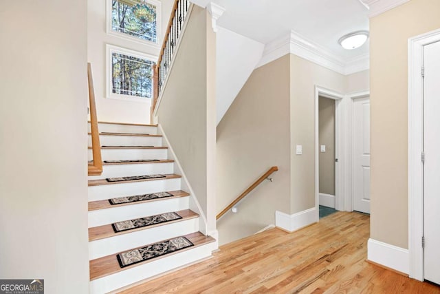 stairway with crown molding and hardwood / wood-style flooring