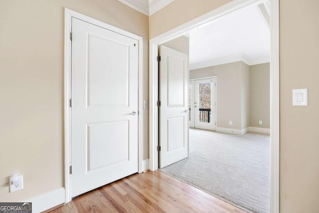 hallway featuring light colored carpet and crown molding