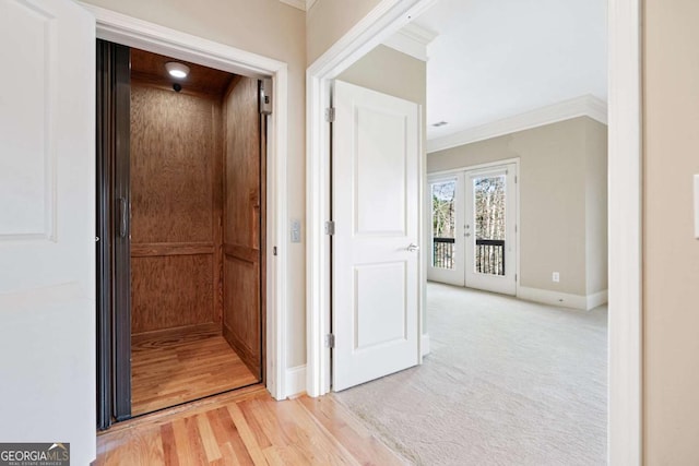 corridor with carpet, french doors, elevator, and crown molding