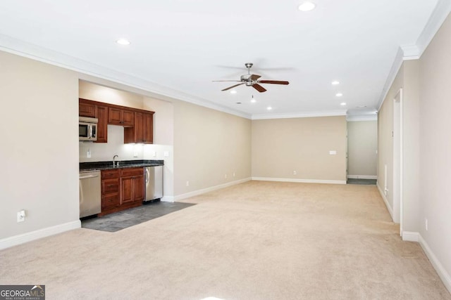 kitchen featuring stainless steel appliances, ceiling fan, ornamental molding, and light colored carpet