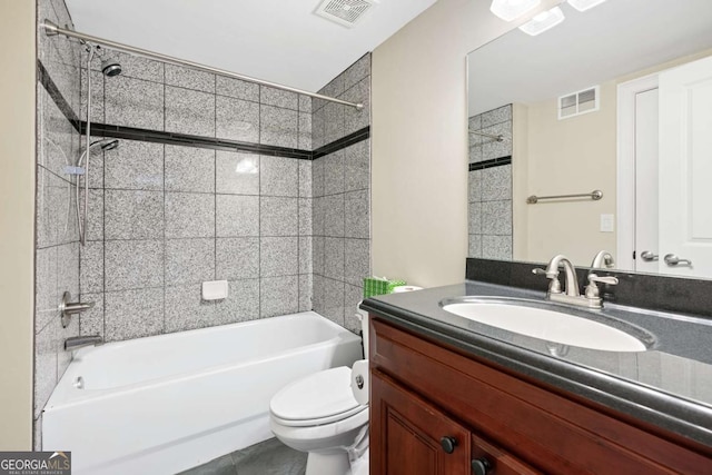 full bathroom featuring vanity, tiled shower / bath combo, toilet, and tile patterned flooring