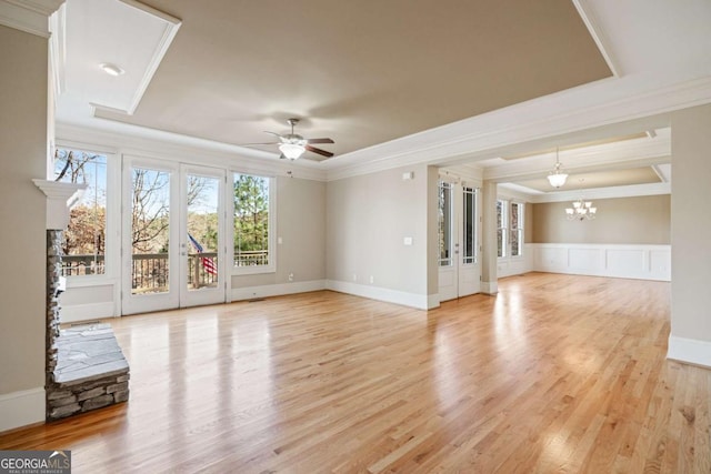 unfurnished living room featuring light wood-type flooring, ceiling fan with notable chandelier, and ornamental molding