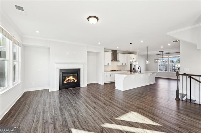 unfurnished living room featuring ornamental molding and dark wood-type flooring