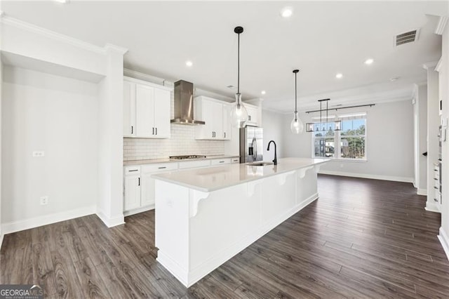 kitchen with stainless steel appliances, white cabinetry, wall chimney exhaust hood, and a spacious island