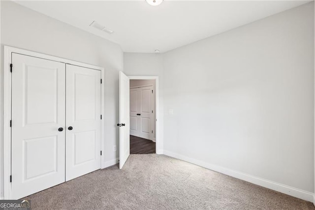 unfurnished bedroom with carpet flooring and a closet