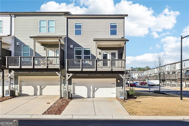 townhome / multi-family property featuring central AC unit and a garage