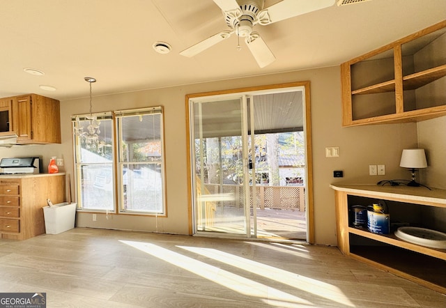 kitchen featuring ceiling fan, light hardwood / wood-style flooring, and hanging light fixtures