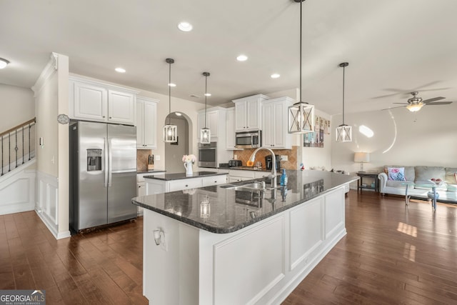 kitchen with tasteful backsplash, stainless steel appliances, sink, pendant lighting, and white cabinets