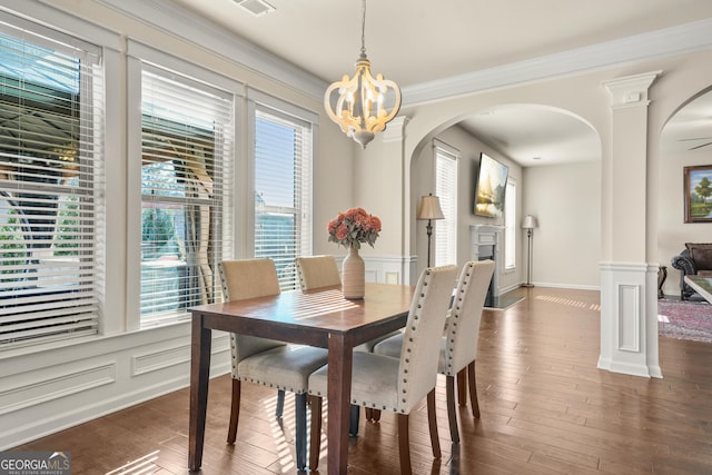 dining space featuring dark hardwood / wood-style flooring, crown molding, and a notable chandelier