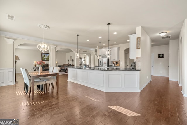 kitchen featuring white cabinetry, dark hardwood / wood-style floors, decorative light fixtures, and an inviting chandelier