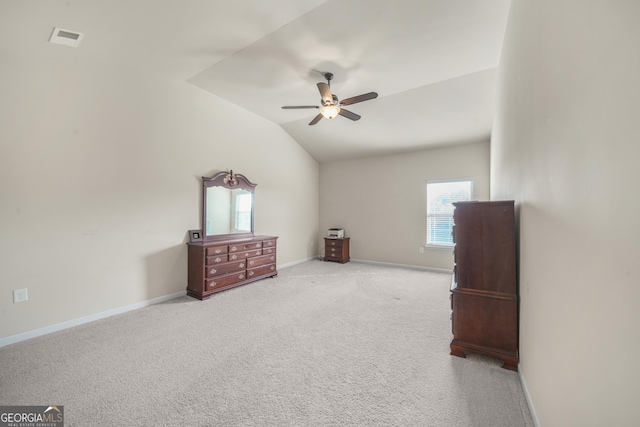 interior space with multiple windows, light colored carpet, vaulted ceiling, and ceiling fan