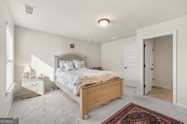 bedroom featuring light colored carpet and multiple windows