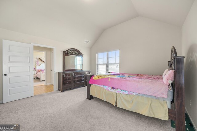 bedroom with light colored carpet and vaulted ceiling