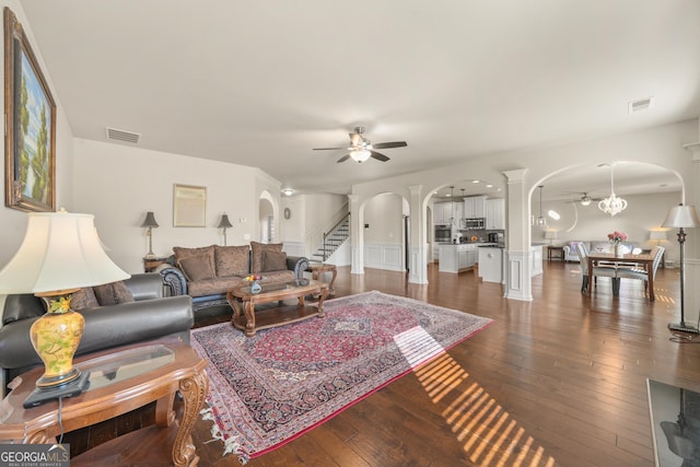 living room featuring ceiling fan and dark wood-type flooring