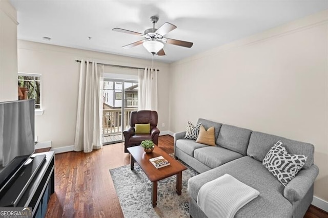 living room featuring ceiling fan and dark hardwood / wood-style flooring